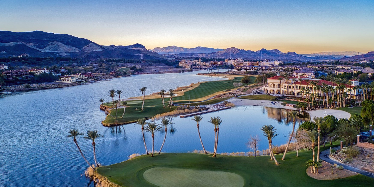 Lake and golf course community with mountain views in Henderson, Nevada at sunset